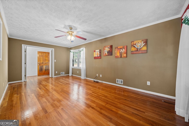 empty room featuring ornamental molding, a textured ceiling, light hardwood / wood-style floors, and ceiling fan