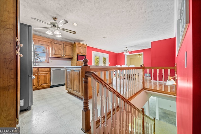 kitchen featuring a textured ceiling, stainless steel appliances, and sink