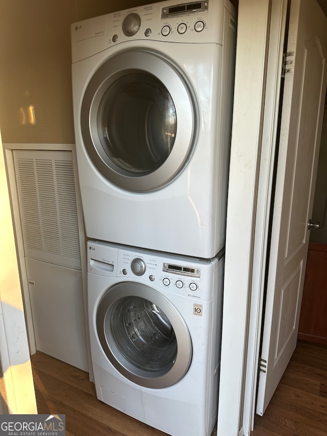 washroom featuring stacked washer and dryer and dark hardwood / wood-style floors