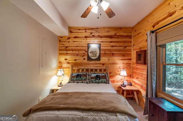 bedroom with wood walls, carpet flooring, and ceiling fan