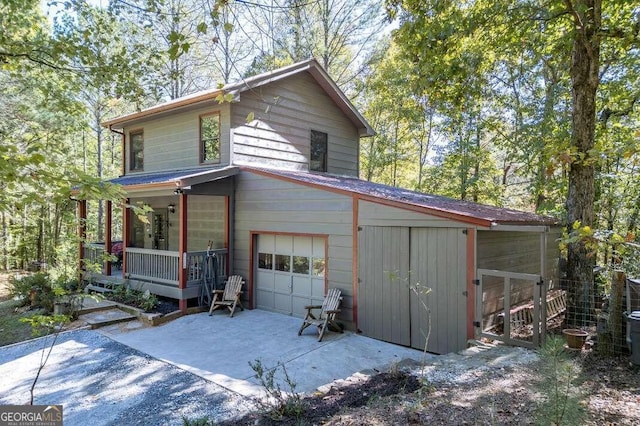 view of side of property with a porch and a garage