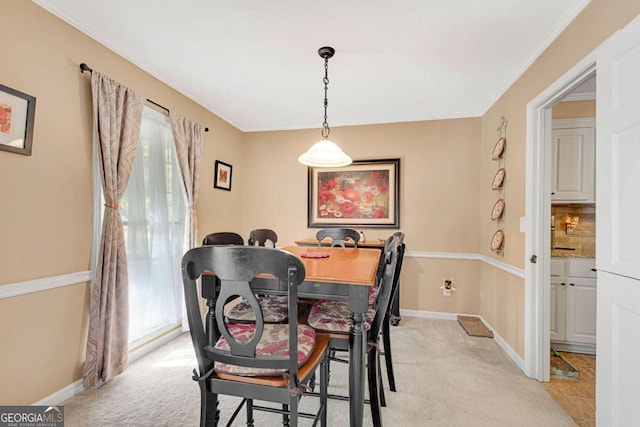 carpeted dining room with crown molding