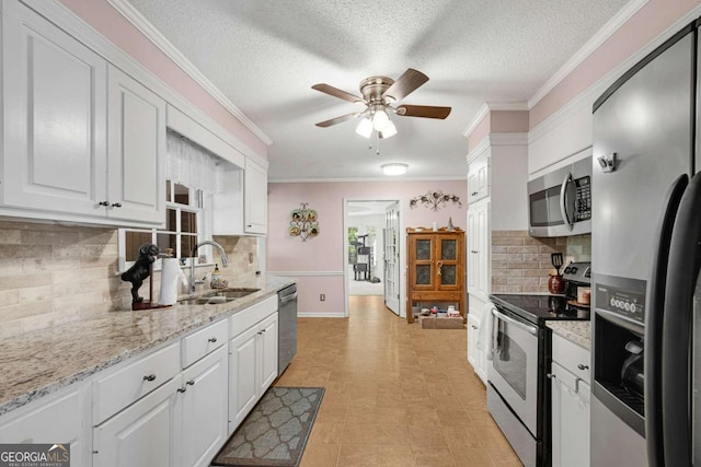 kitchen with decorative backsplash, sink, crown molding, white cabinetry, and appliances with stainless steel finishes