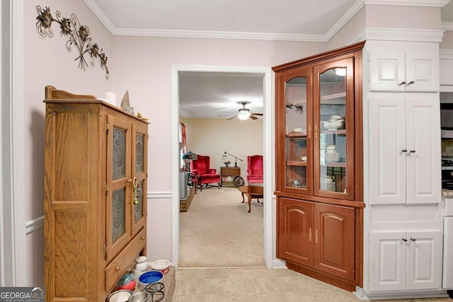 hall featuring light carpet, ornamental molding, and a textured ceiling