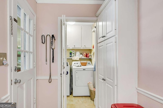 laundry area featuring crown molding, cabinets, and washing machine and clothes dryer