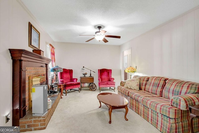 living room with ceiling fan, a textured ceiling, carpet floors, and a fireplace