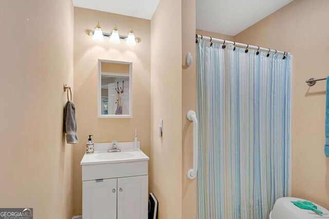 bathroom featuring vanity, curtained shower, and toilet