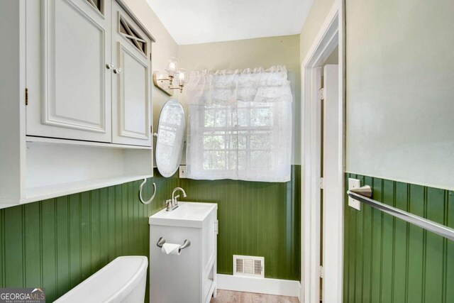 bathroom featuring toilet, hardwood / wood-style flooring, and vanity