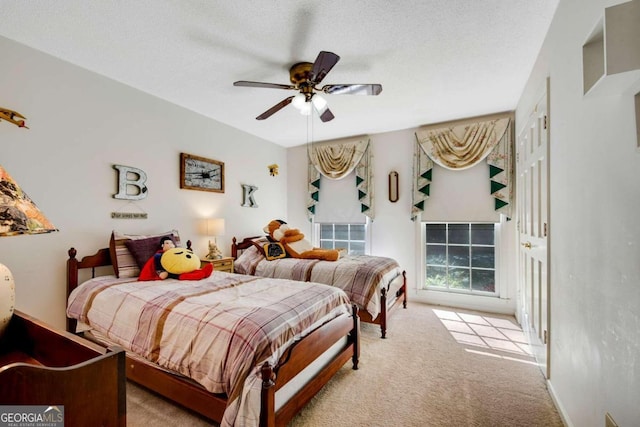 carpeted bedroom featuring ceiling fan and a textured ceiling