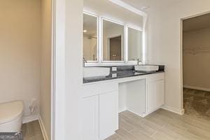 319 Brooks Dr Unit 73, Fairburn, GA 30213 - full bath featuring double vanity, toilet, a spacious closet, baseboards, and wood finished floors