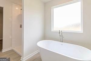 bathroom featuring independent shower and bath, wood-type flooring, and plenty of natural light