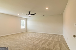 empty room featuring light carpet and ceiling fan