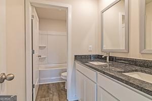 319 Brooks Dr Unit 73, Fairburn, GA 30213 - full bath with double vanity, toilet, wood finished floors, and bathing tub / shower combination