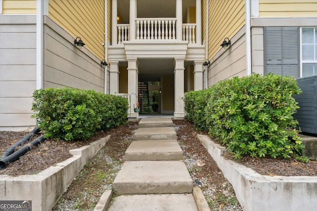 view of exterior entry with a balcony