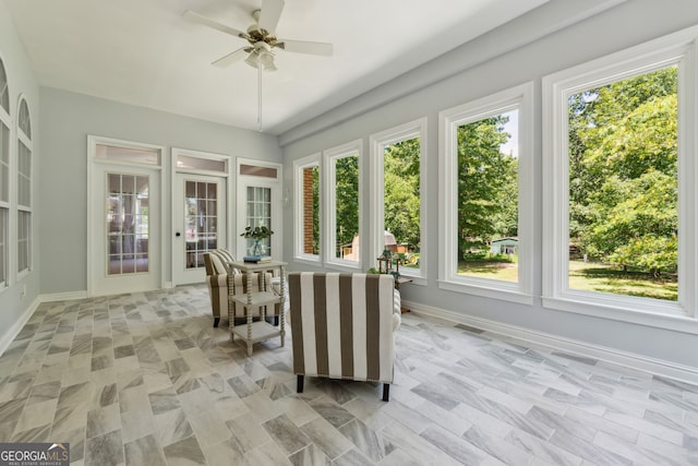 sunroom featuring ceiling fan and plenty of natural light