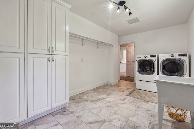 washroom with cabinets and washing machine and clothes dryer