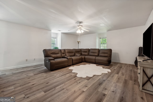 living room with light hardwood / wood-style floors and ceiling fan