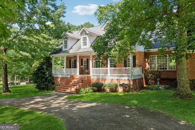 new england style home featuring a front yard and a porch