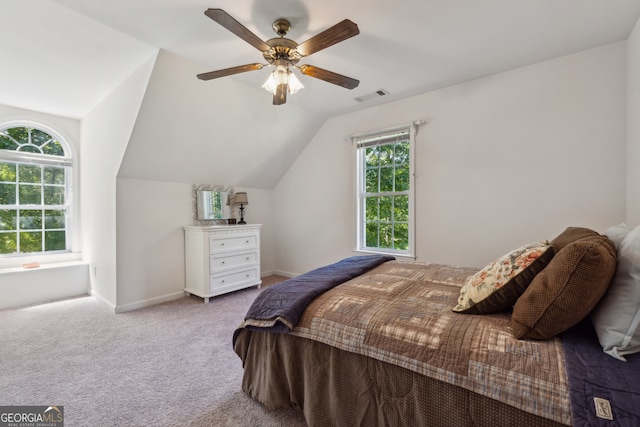 bedroom with ceiling fan, lofted ceiling, and light colored carpet