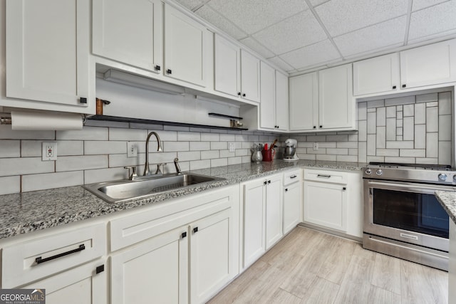 kitchen with white cabinetry, sink, and stainless steel stove