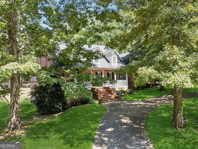 cape cod-style house featuring a porch and a front lawn