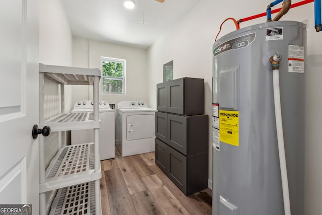 laundry area featuring electric water heater, light hardwood / wood-style flooring, and separate washer and dryer