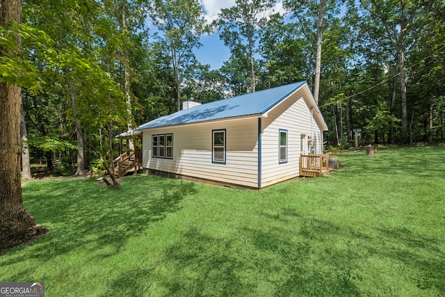 view of side of property with a wooden deck and a lawn