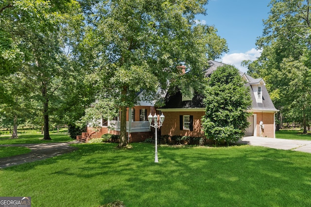 view of property hidden behind natural elements with a garage and a front lawn