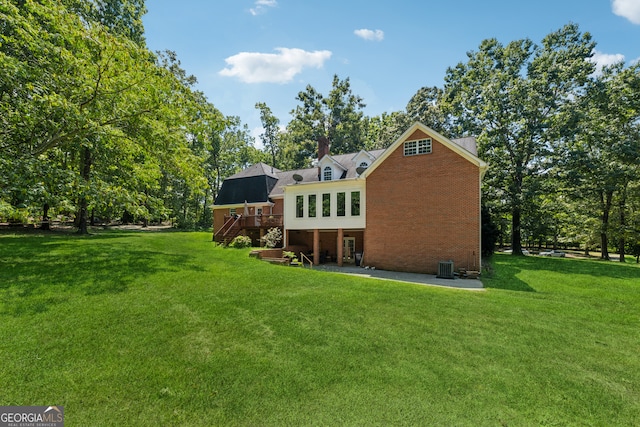 rear view of house featuring a patio, a deck, and a lawn