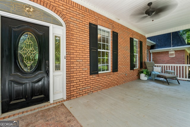 view of exterior entry with ceiling fan and a porch