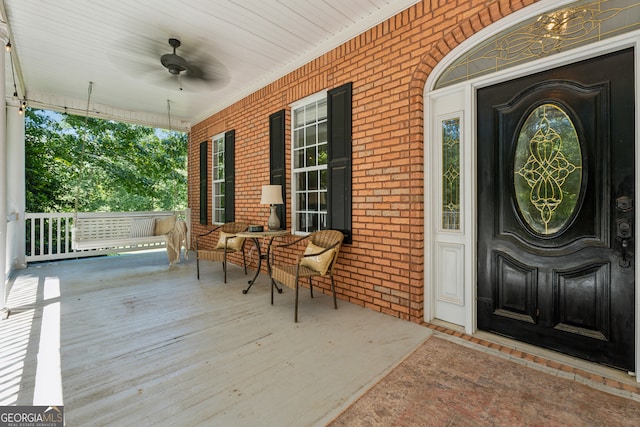 entrance to property with covered porch and ceiling fan