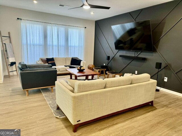 living room with ceiling fan and light wood-type flooring