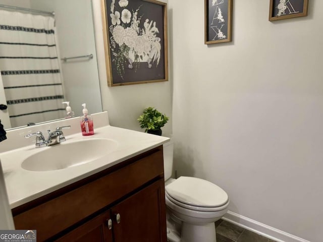 bathroom featuring vanity, toilet, and tile patterned flooring