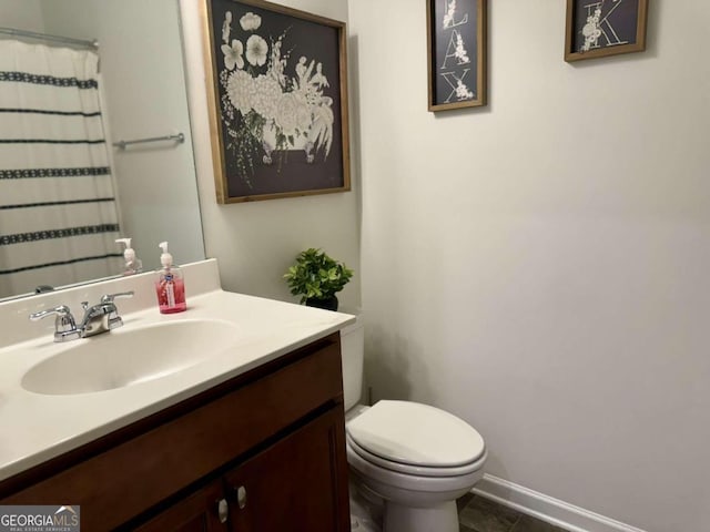 bathroom with toilet, vanity, and tile patterned floors