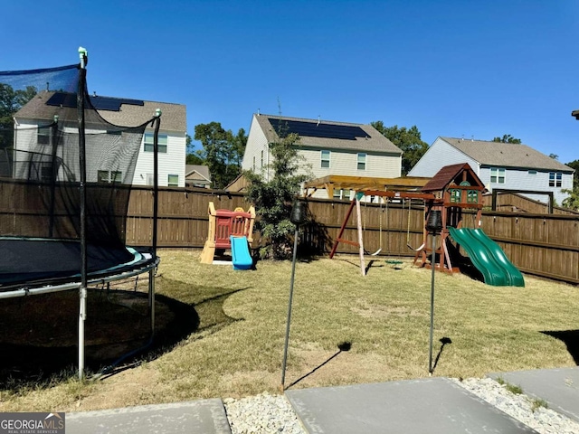 view of jungle gym featuring a trampoline and a lawn