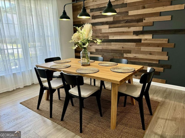 dining room with wooden walls and light wood-type flooring