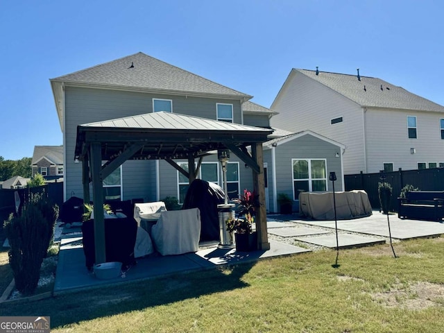 back of property featuring a gazebo, a lawn, and a patio area