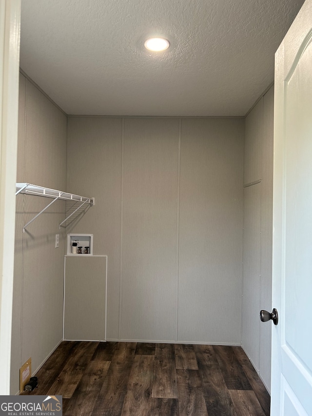 laundry room featuring a textured ceiling, washer hookup, and dark hardwood / wood-style flooring