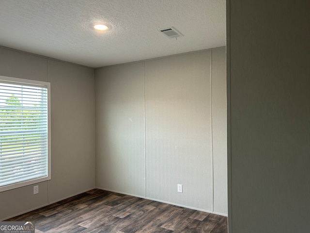 unfurnished room with dark hardwood / wood-style floors and a textured ceiling