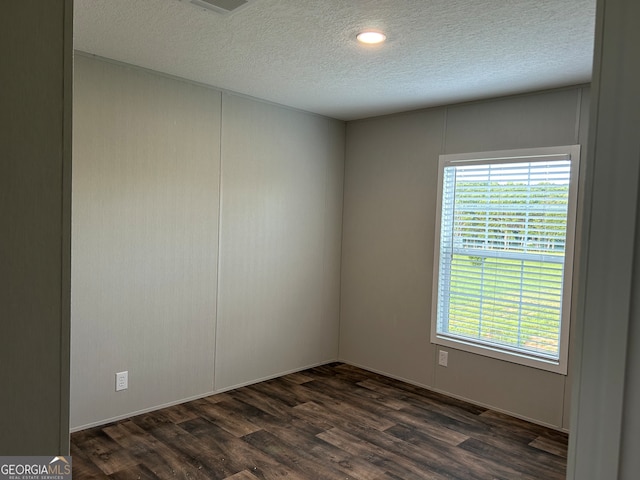 unfurnished room featuring a textured ceiling and dark wood-type flooring