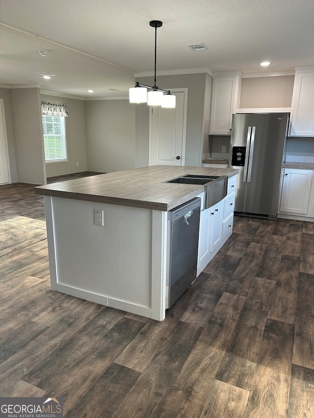 kitchen with appliances with stainless steel finishes, dark hardwood / wood-style floors, and white cabinetry