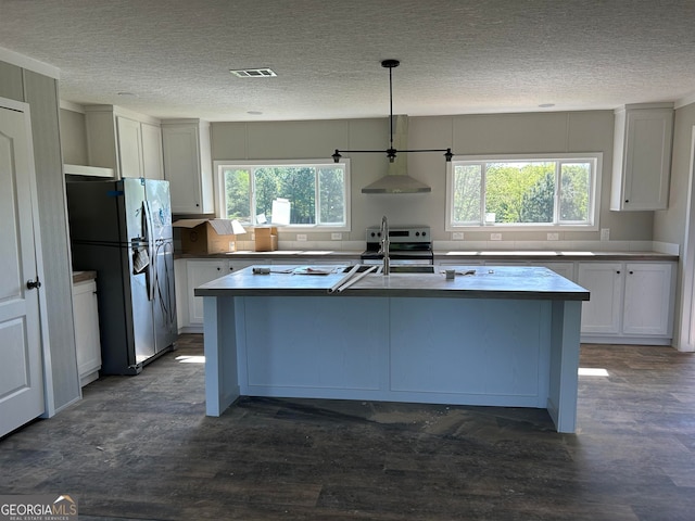 kitchen with stainless steel appliances, decorative light fixtures, plenty of natural light, and white cabinets