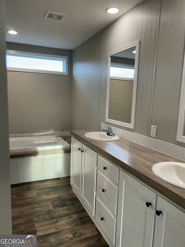 bathroom featuring vanity, hardwood / wood-style floors, and a bathtub