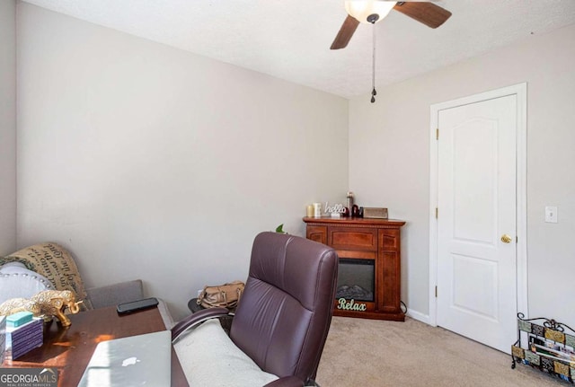 carpeted office space featuring ceiling fan