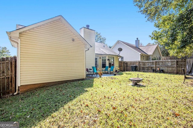 back of property with an outdoor fire pit, a patio, and a lawn