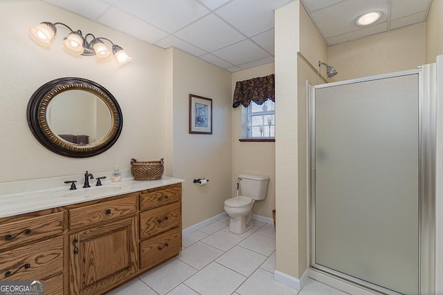 bathroom with vanity, tile patterned flooring, a shower with door, and a drop ceiling