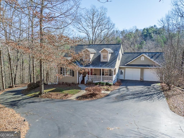 cape cod-style house featuring a garage and a porch