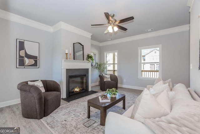 living room featuring crown molding, light wood-type flooring, and ceiling fan