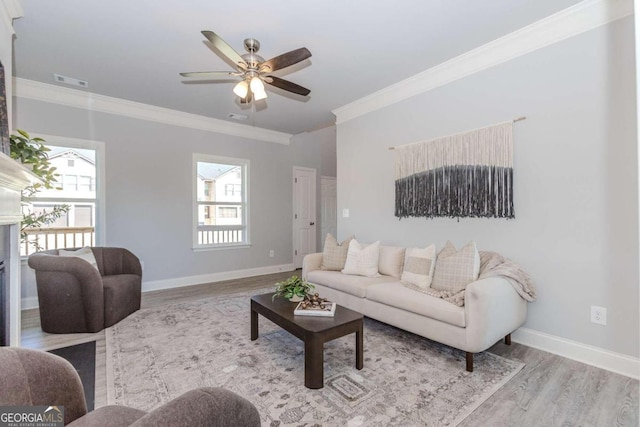 living room with ceiling fan, ornamental molding, and light hardwood / wood-style flooring