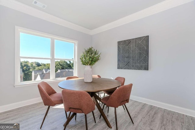 dining room featuring light hardwood / wood-style floors and ornamental molding